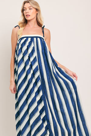 Woman wearing a blue and white striped maxi dress with shoulder ties and smocked back band | Flying Tomato