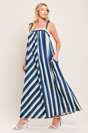 Woman wearing a blue and white striped maxi dress with shoulder ties and smocked back band | Flying Tomato
