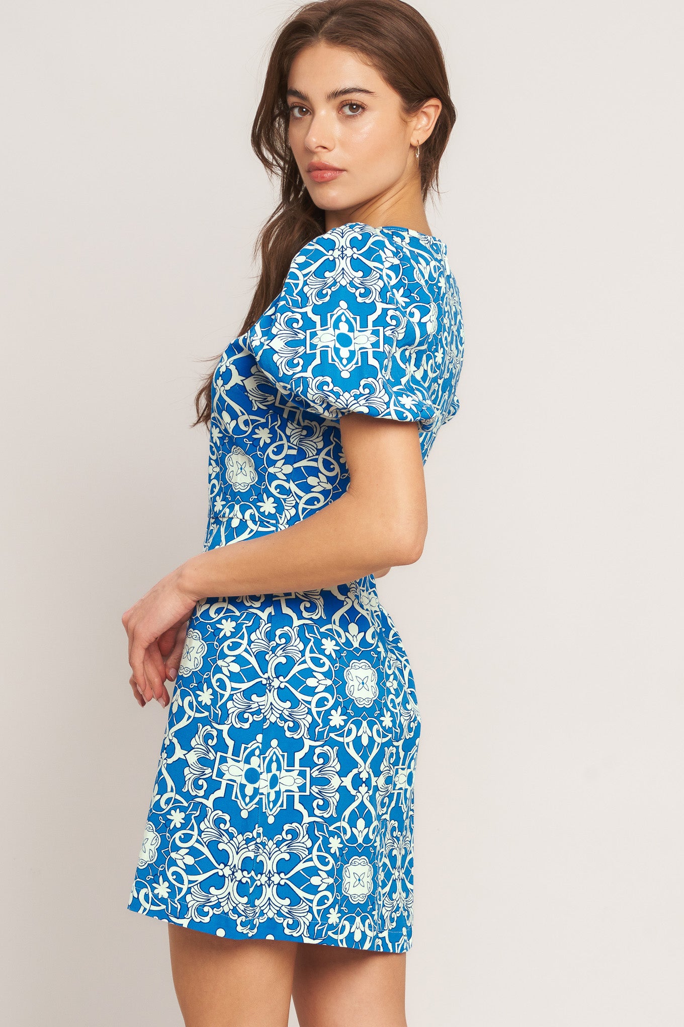 A printed woven mini dress featuring round neckline, short puff sleeve and back zipper closure