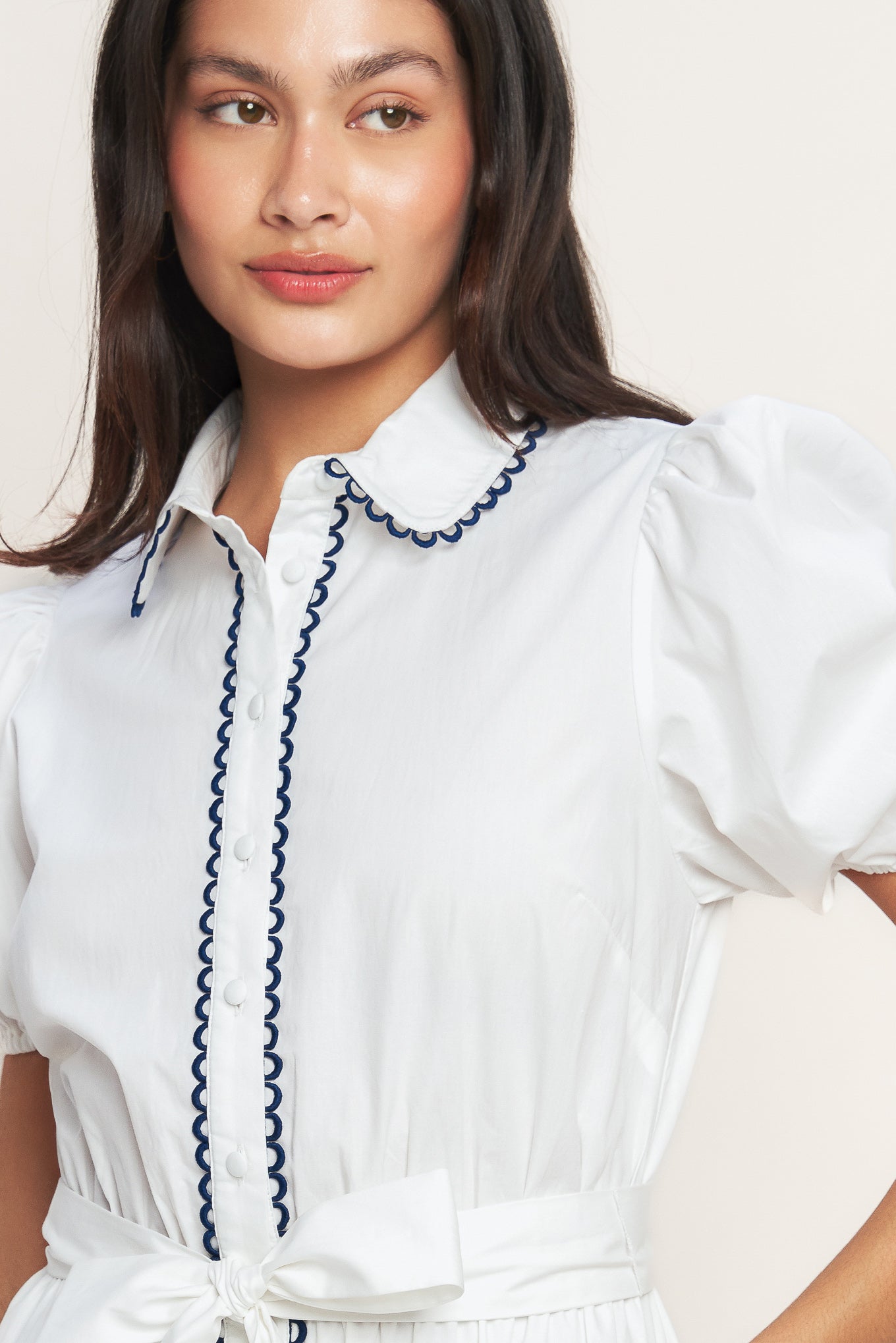 White short-sleeve button-front dress with navy trim and waist tie
