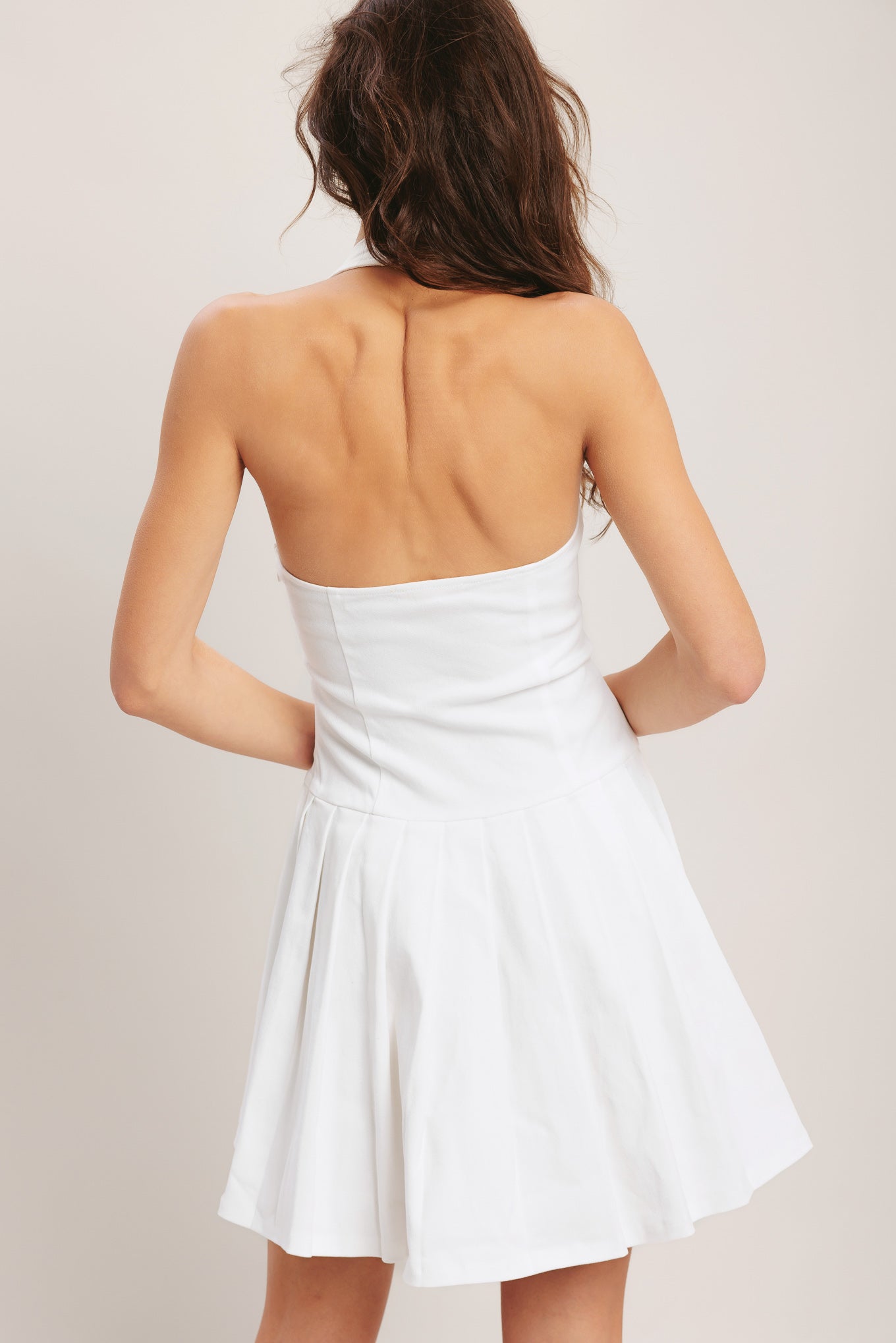 
A solid woven mini dress featuring halter neckline, front button detail, dropped waistline, knife pleated skirt, side zipper and back neck button closure

Details:

Self : 97% Cotton 35 Spandex

Size &amp; Fit

- Model is 5`8" And Wearing Size Small
- Measurements Taken From Size Small
- Approx. Length: 35"