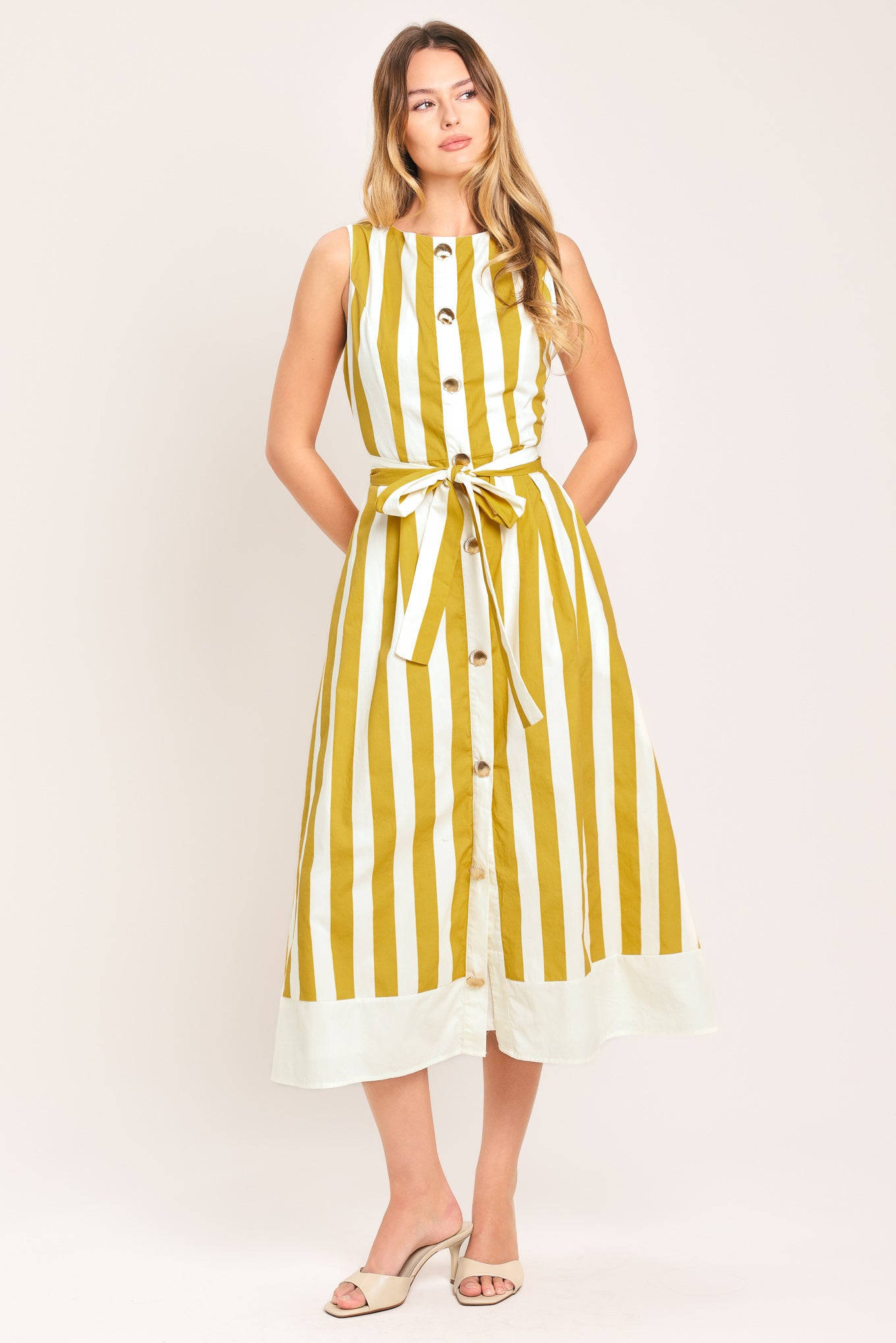 Woman wearing a yellow and white striped midi dress featuring round neckline, sleeveless, self sash tie, full skirt and back zipper closure | Flying Tomato