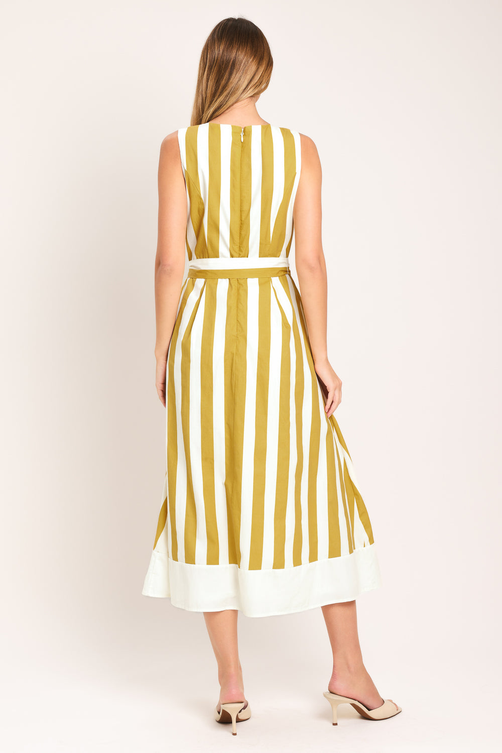 Woman wearing a yellow and white striped midi dress featuring round neckline, sleeveless, self sash tie, full skirt and back zipper closure | Flying Tomato