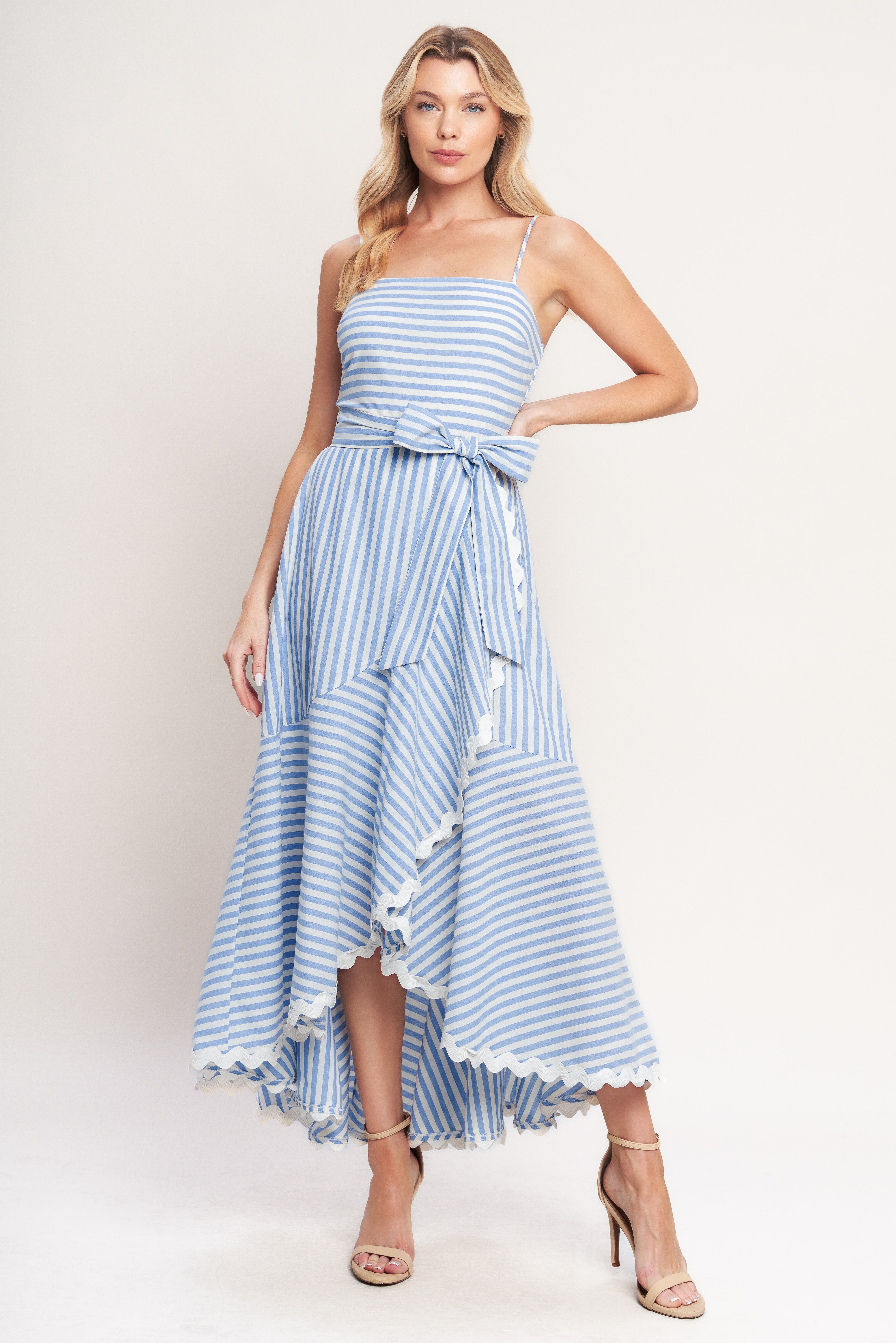 Blue-and-white striped midi dress with delicate straps, a waist bow tie, and a ruffled high-low hem.