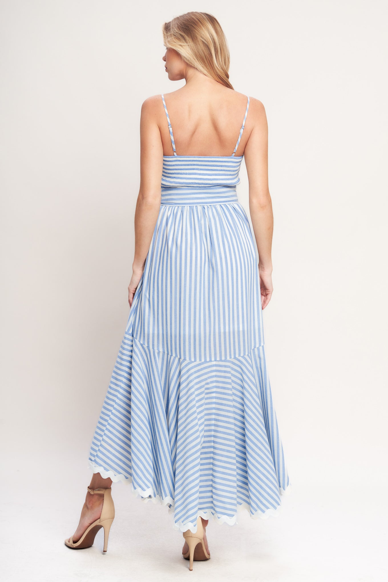 Blue-and-white striped midi dress with delicate straps, a waist bow tie, and a ruffled high-low hem

Details:

Self: 100% Cotton
Lining: 100% Polyester Exclusive of Decoration

Size & Fit

- Model is 5`8" And Wearing Size Small
- Measurements Taken From Size Small
- Approx. Length: 53"