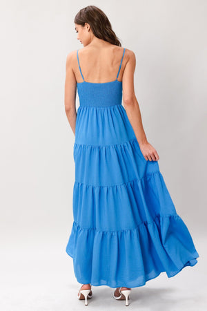 Woman wearing a blue tiered solid woven maxi dress featuring lace bodice with front tie, straps, tier skirt and smocked back bodice