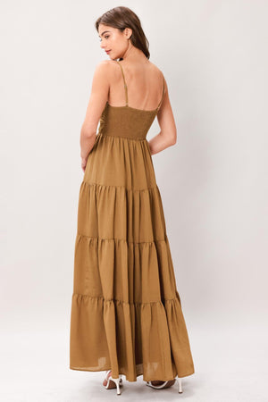 Woman wearing a brown tiered solid woven maxi dress featuring lace bodice with front tie, straps, tier skirt and smocked back bodice