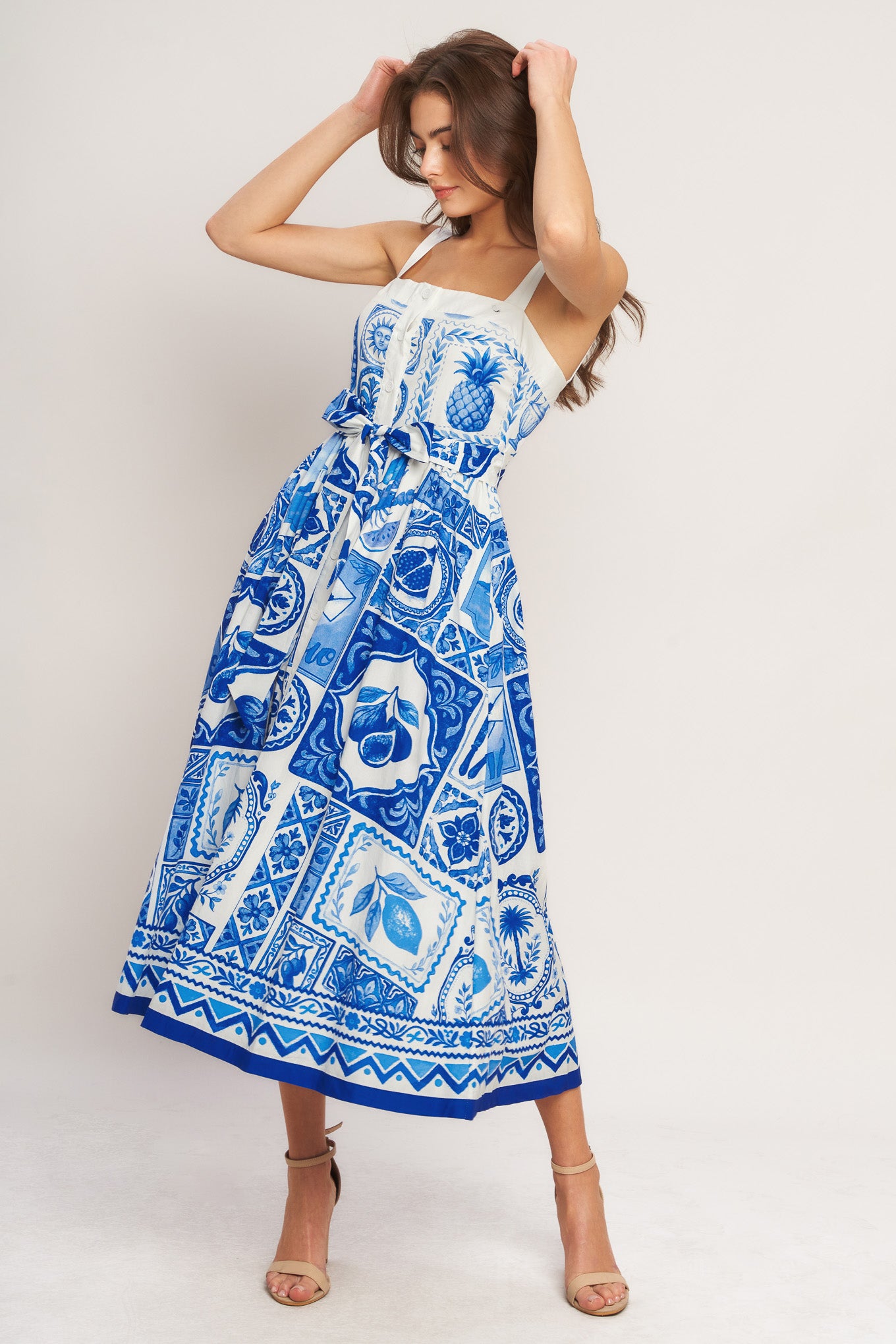 Woman wearing a blue and white patterned dress on a white background
