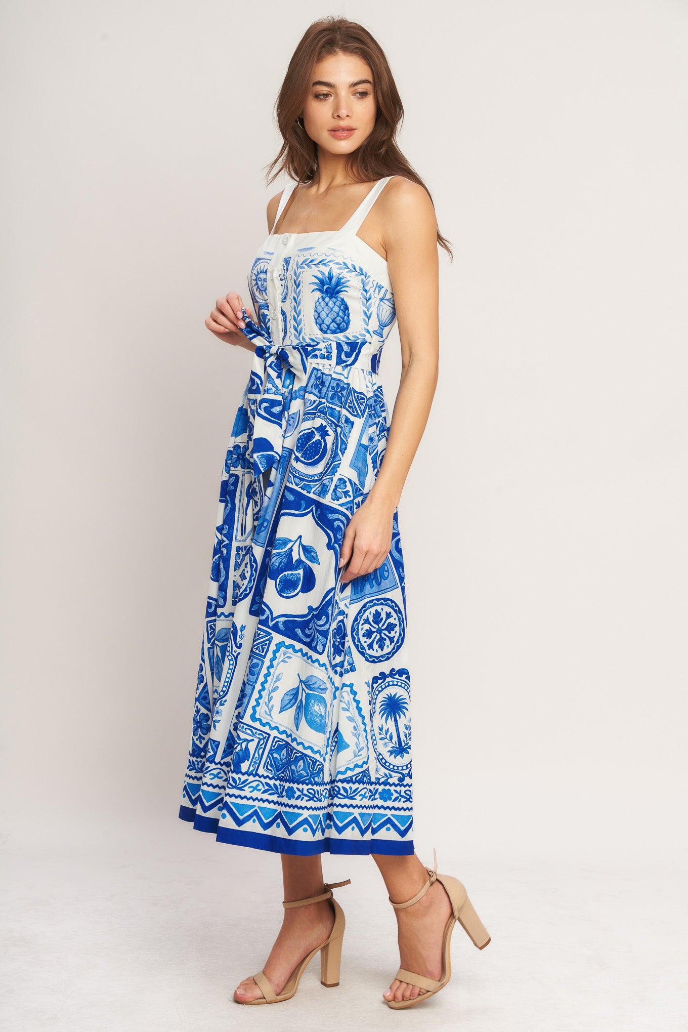 Woman wearing a blue and white patterned dress on a white background