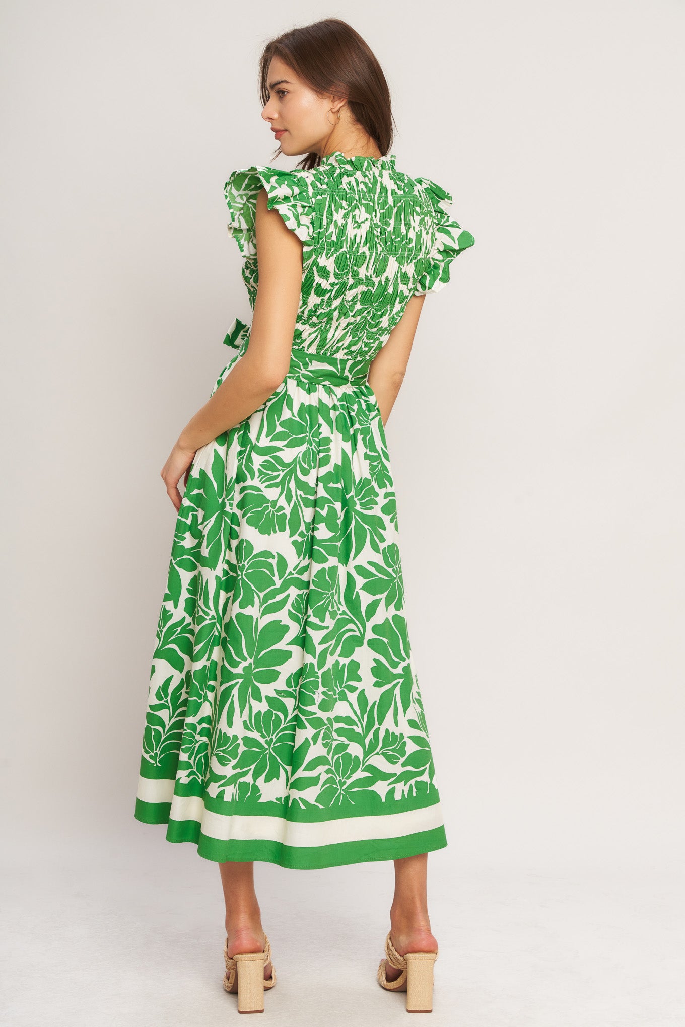A printed woven midi dress featuring ruffled neck with V front, ruffle sleeve, smocked bodice and full skirt