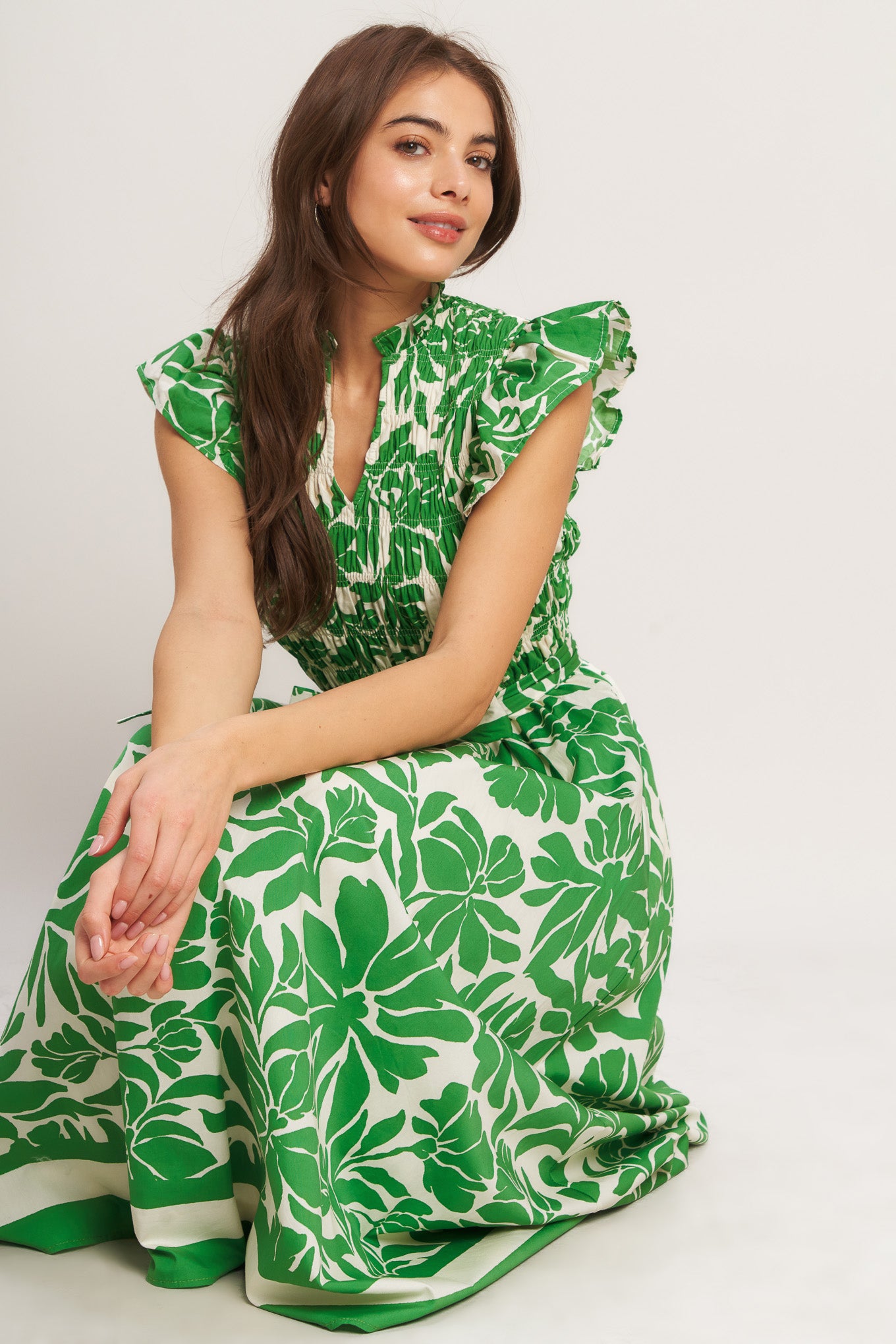 A printed woven midi dress featuring ruffled neck with V front, ruffle sleeve, smocked bodice and full skirt