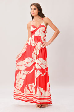 Woman wearing a red floral maxi dress featuring cami top, waist yoke, full skirt, bare back with tie and smocked waistband | Flying Tomato