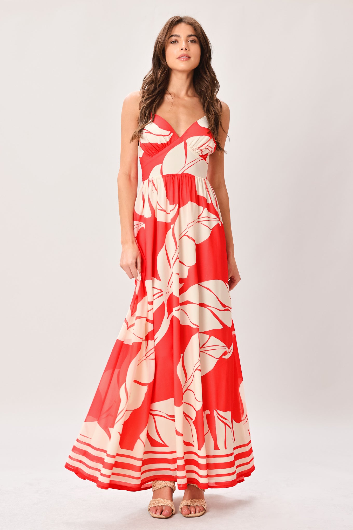 Woman wearing a red floral maxi dress featuring cami top, waist yoke, full skirt, bare back with tie and smocked waistband | Flying Tomato