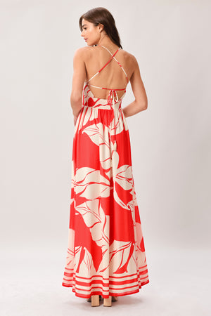Woman wearing a red floral maxi dress featuring cami top, waist yoke, full skirt, bare back with tie and smocked waistband | Flying Tomato