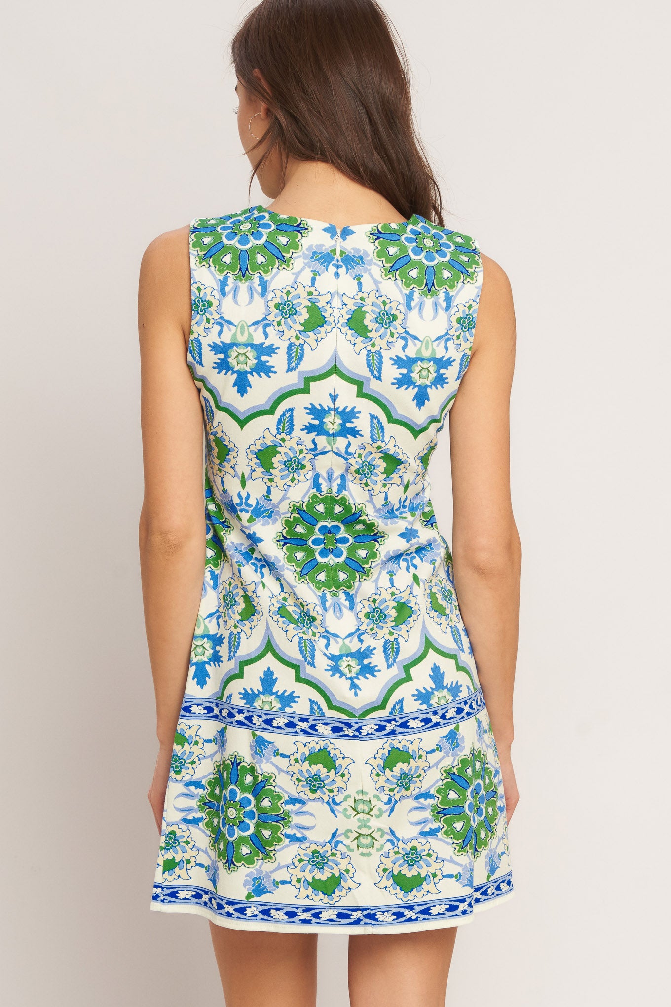 A printed woven mini dress featuring round neckline, sleeveless and back zipper closure