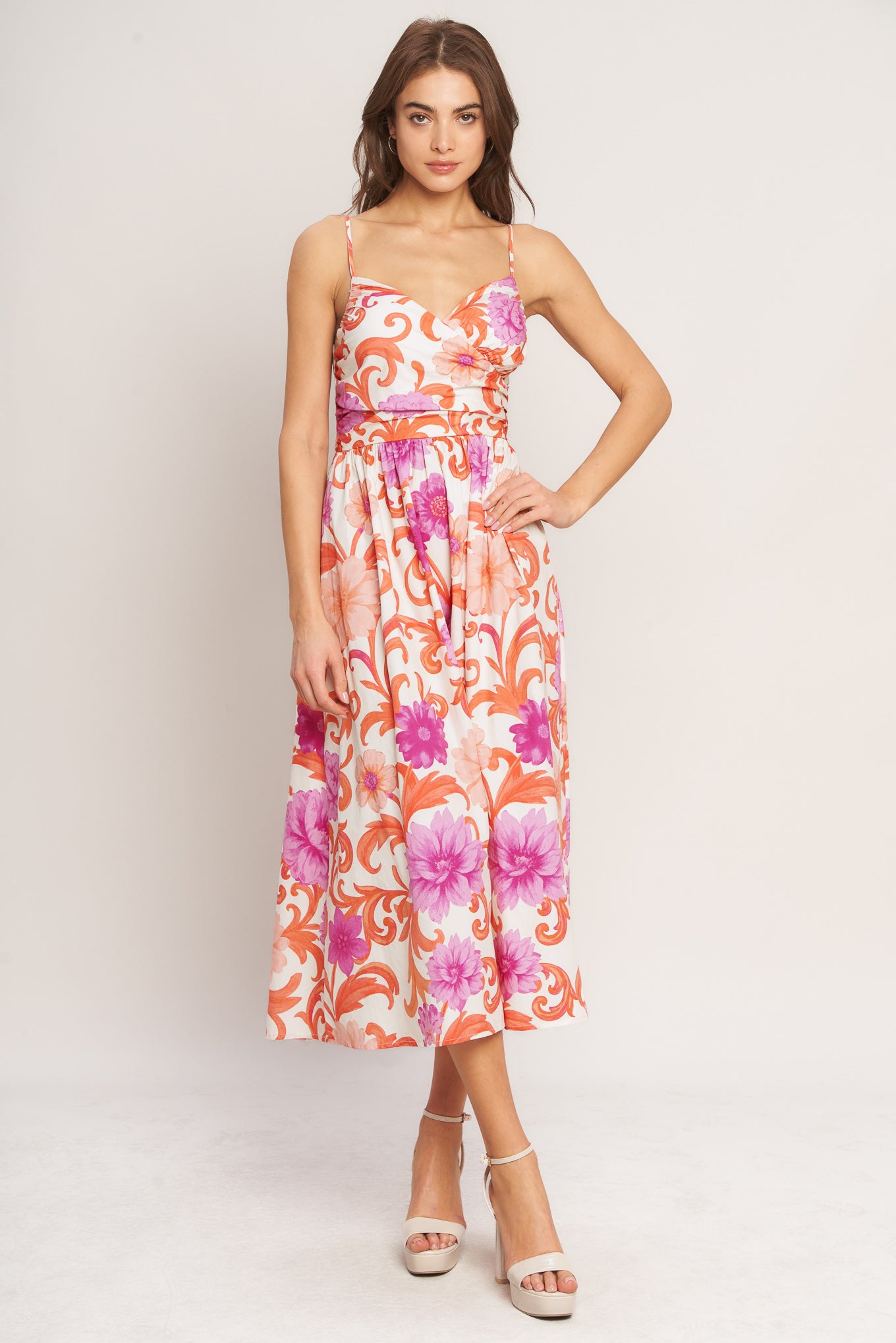 A printed woven midi dress featuring surplice cami top with shirred side, straps, full skirt and smocked back bodice