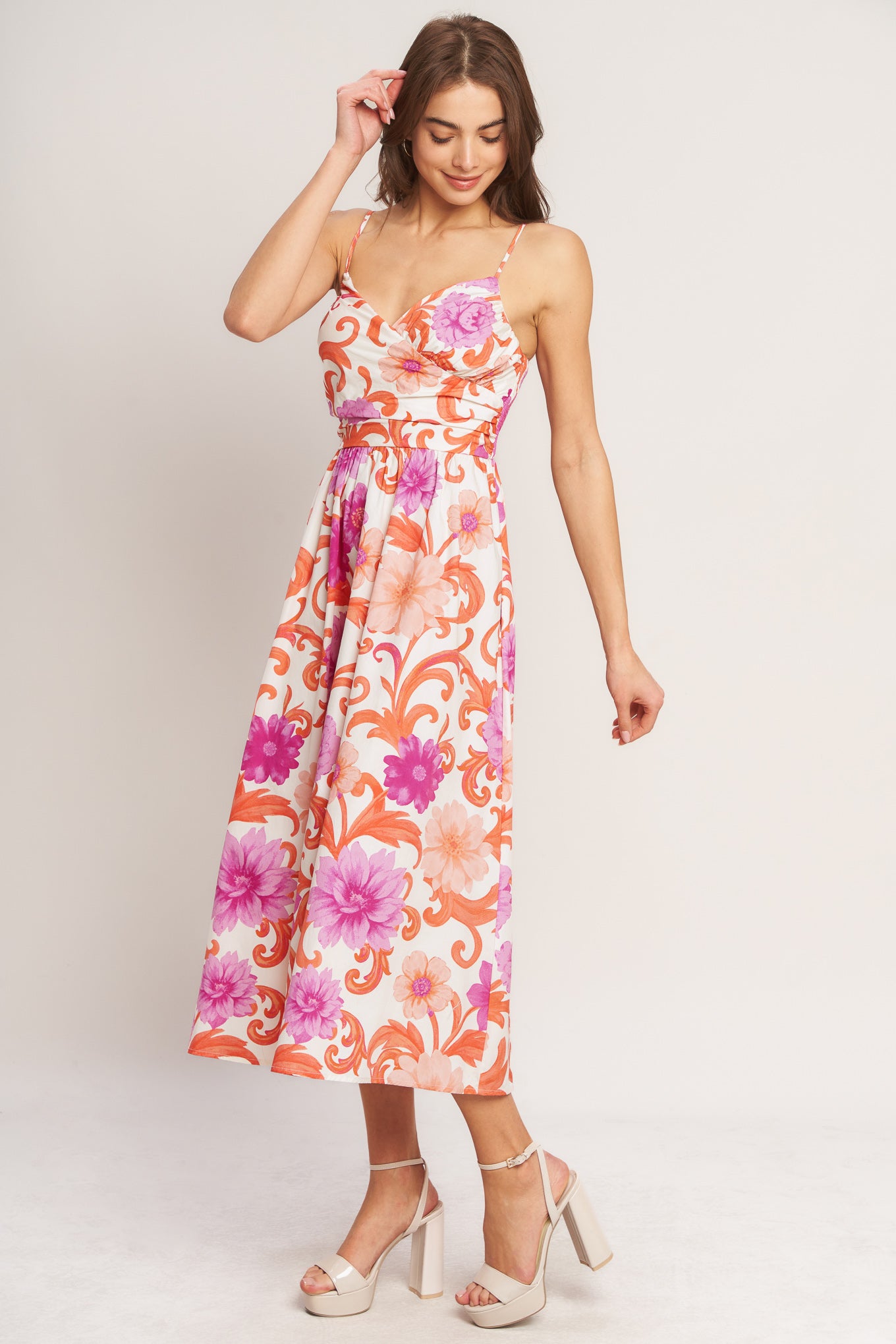 A printed woven midi dress featuring surplice cami top with shirred side, straps, full skirt and smocked back bodice