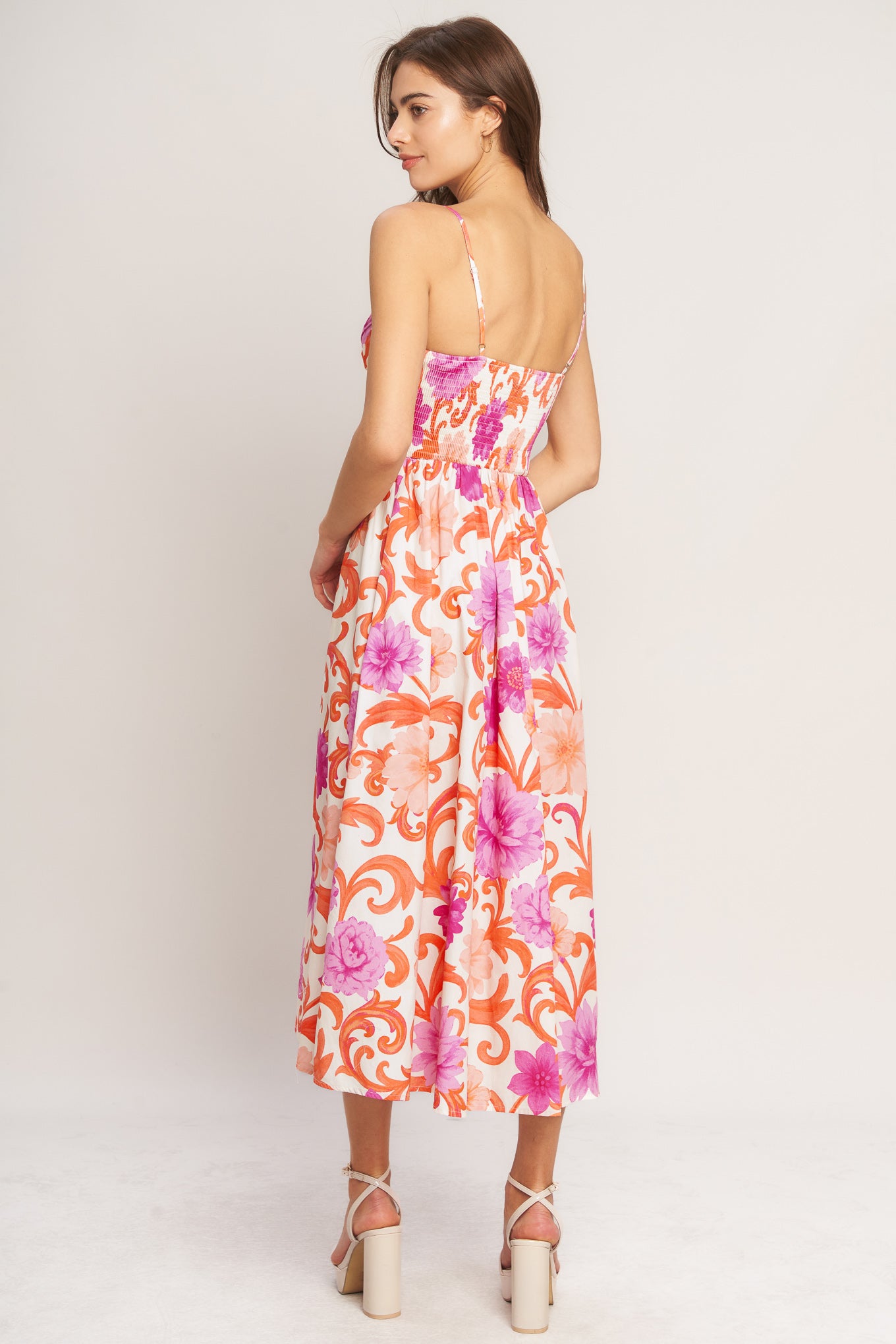 A printed woven midi dress featuring surplice cami top with shirred side, straps, full skirt and smocked back bodice