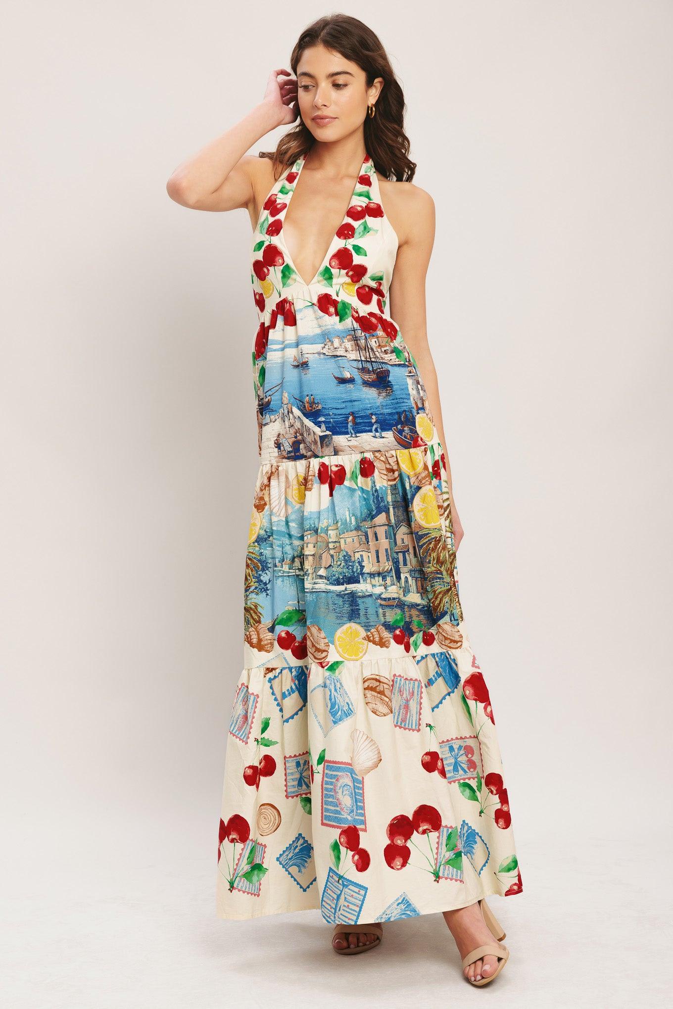 Woman wearing a colorful dress with a scenic print on a plain background