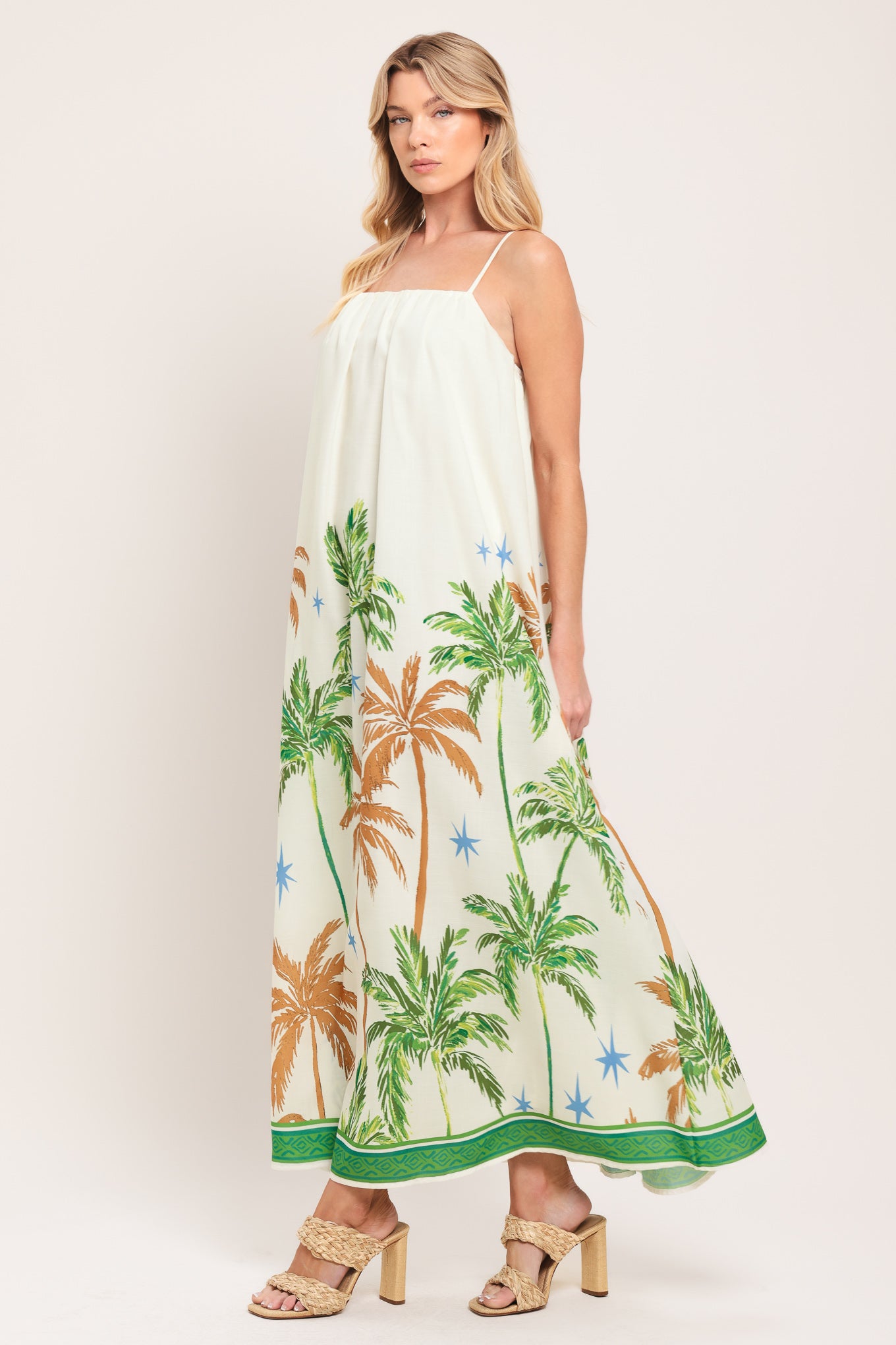 Woman wearing a white dress with green and rustic orange palm tree pattern | Flying Tomato