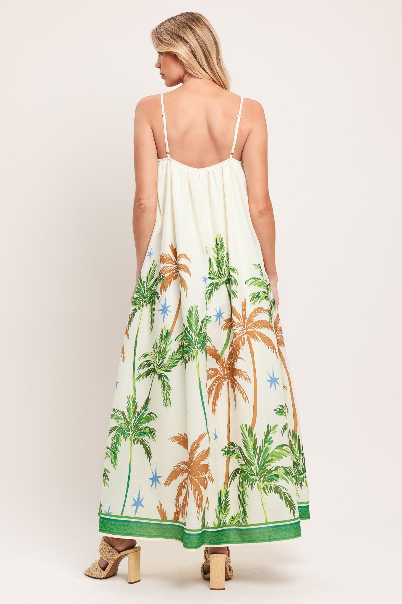 Woman wearing a white dress with green and rustic orange palm tree pattern | Flying Tomato