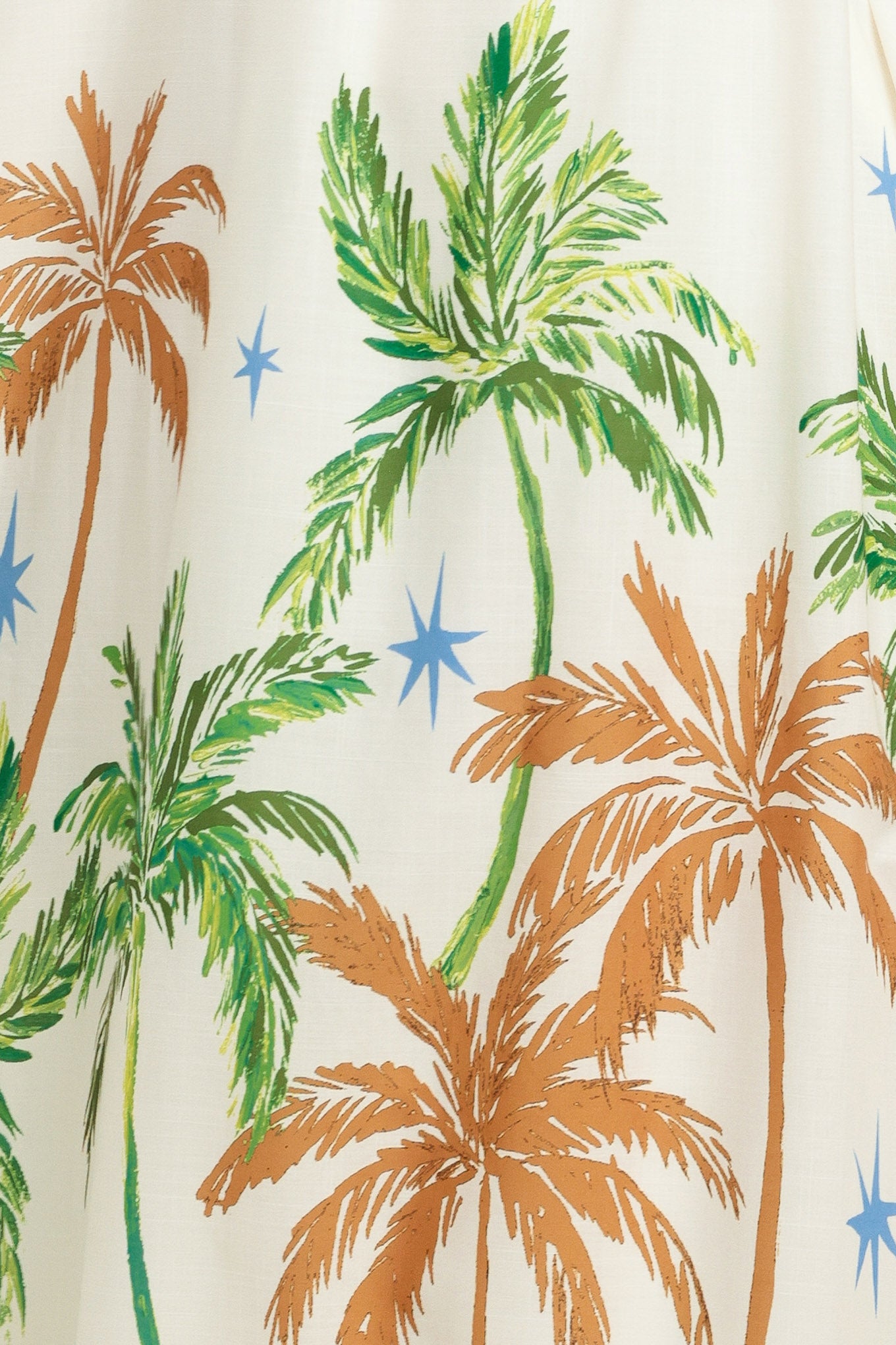 Woman wearing a white dress with green and rustic orange palm tree pattern | Flying Tomato