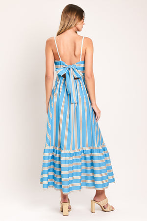 Woman wearing a blue and white striped midi dress featuring straight neckline, braided strap, circle skirt, ruffle hem, bare back with tie closure | Flying Tomato