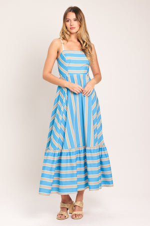 Woman wearing a blue and white striped midi dress featuring straight neckline, braided strap, circle skirt, ruffle hem, bare back with tie closure | Flying Tomato