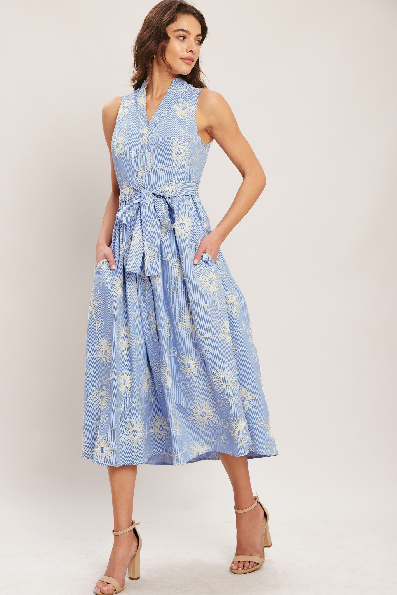 Woman wearing a blue floral dress on a white background
