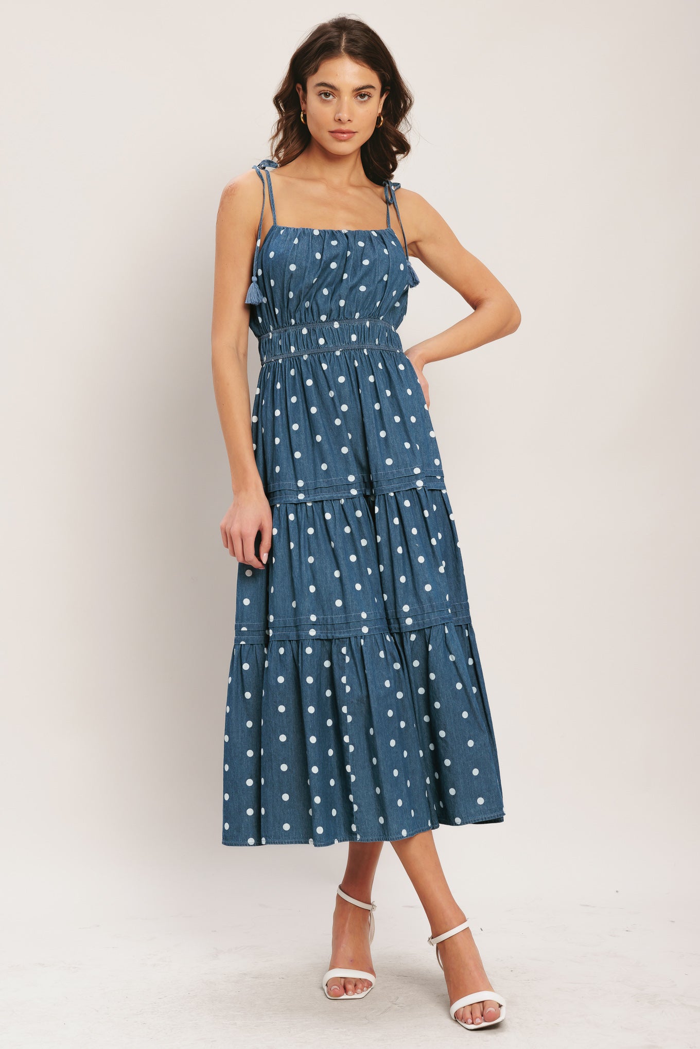 Woman wearing a blue polka dot dress on a white background