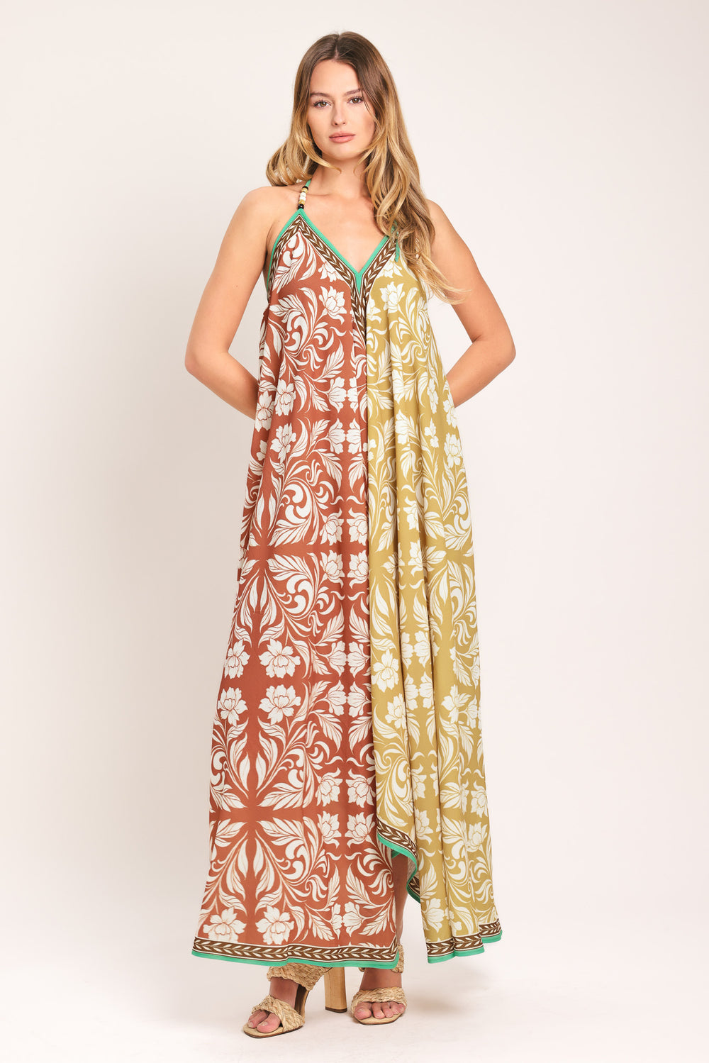 Woman wearing a rust and yellow long, floral patterned midi scarf dress | Flying Tomato