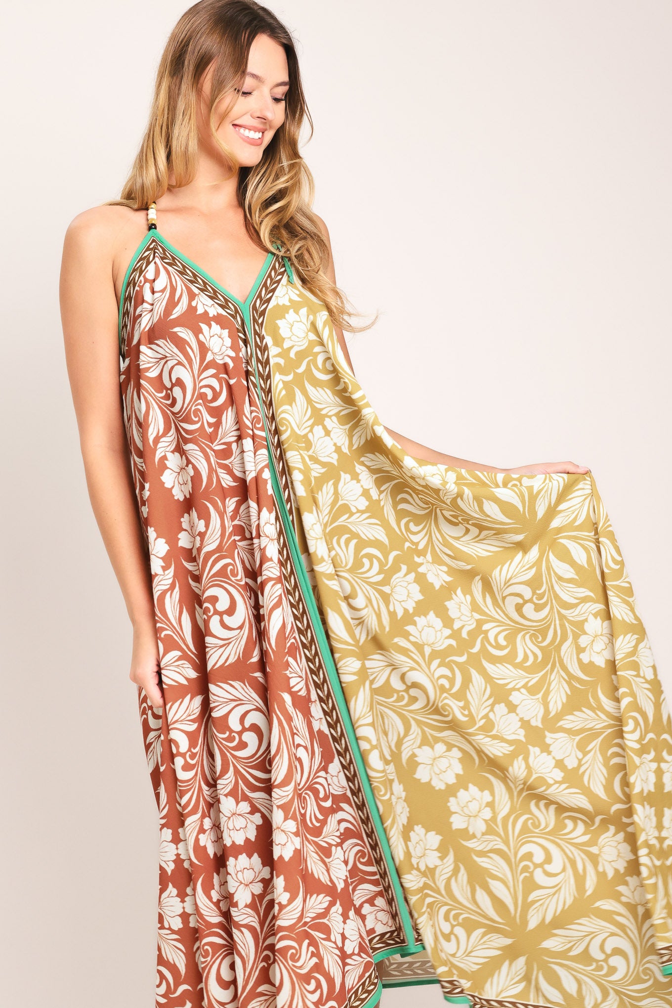 Woman wearing a rust and yellow long, floral patterned midi scarf dress | Flying Tomato