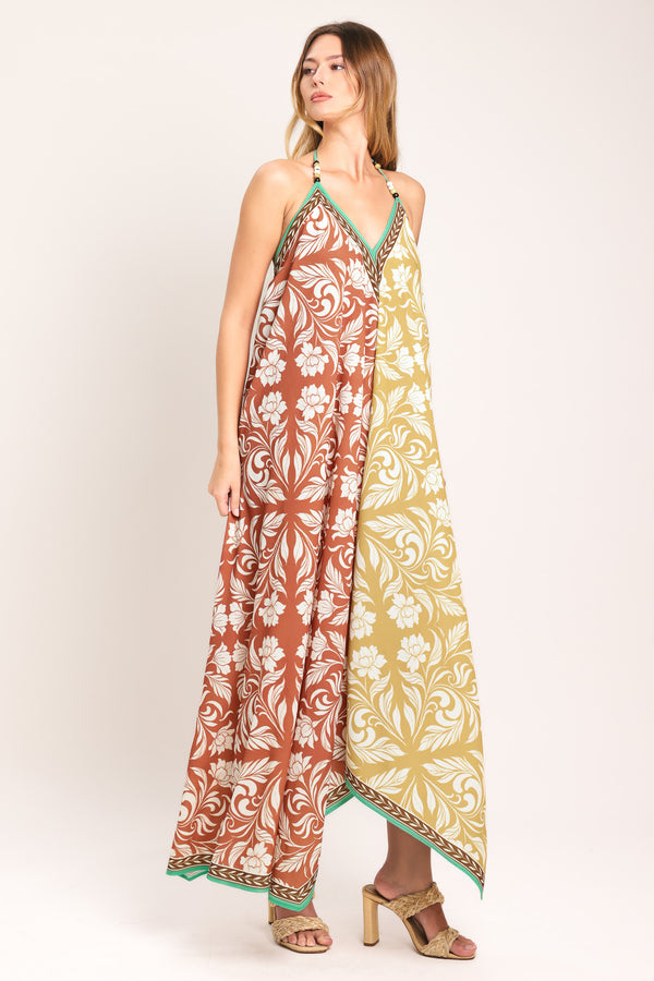 Woman wearing a rust and yellow long, floral patterned midi scarf dress | Flying Tomato