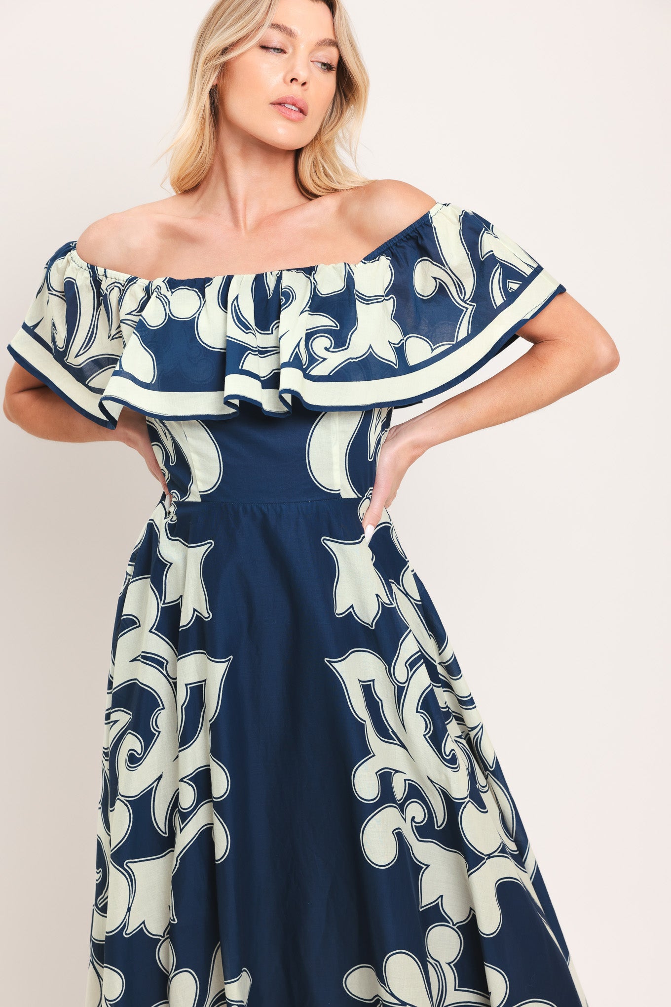 Woman wearing a blue and white patterned off the shoulder midi dress | Flying Tomato
