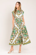 Woman wearing a green, brown, and white patterned midi shirt dress featuring cuffed short sleeve, front button down, self belt and side pockets | Flying Tomato