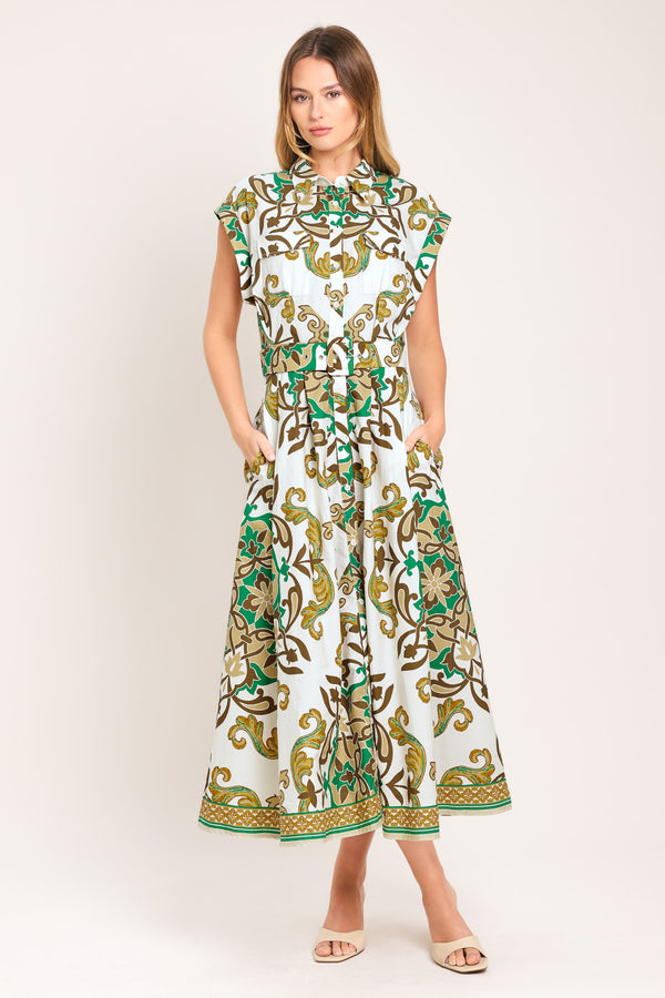 Woman wearing a green, brown, and white patterned midi shirt dress featuring cuffed short sleeve, front button down, self belt and side pockets | Flying Tomato