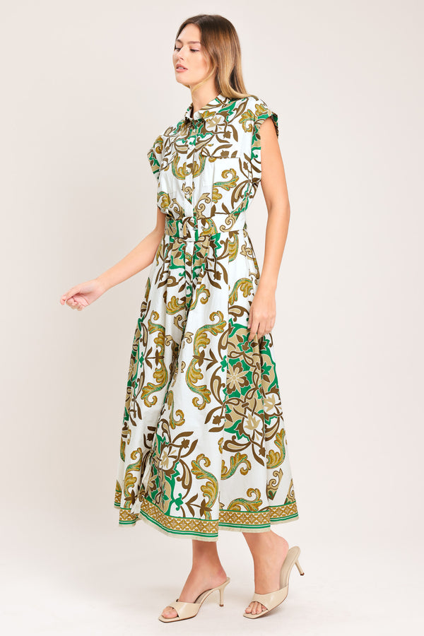 Woman wearing a green, brown, and white patterned midi shirt dress featuring cuffed short sleeve, front button down, self belt and side pockets | Flying Tomato