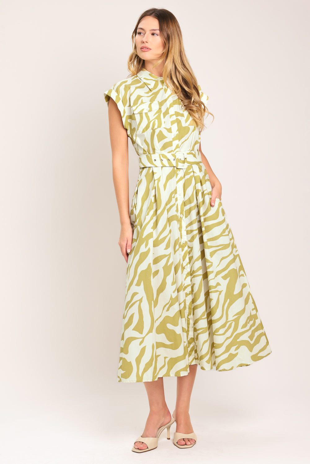 Woman wearing an ivory with taupe zebra printed midi shirt dress featuring cuffed short sleeve, front button down, self belt and side pockets | Flying Tomato