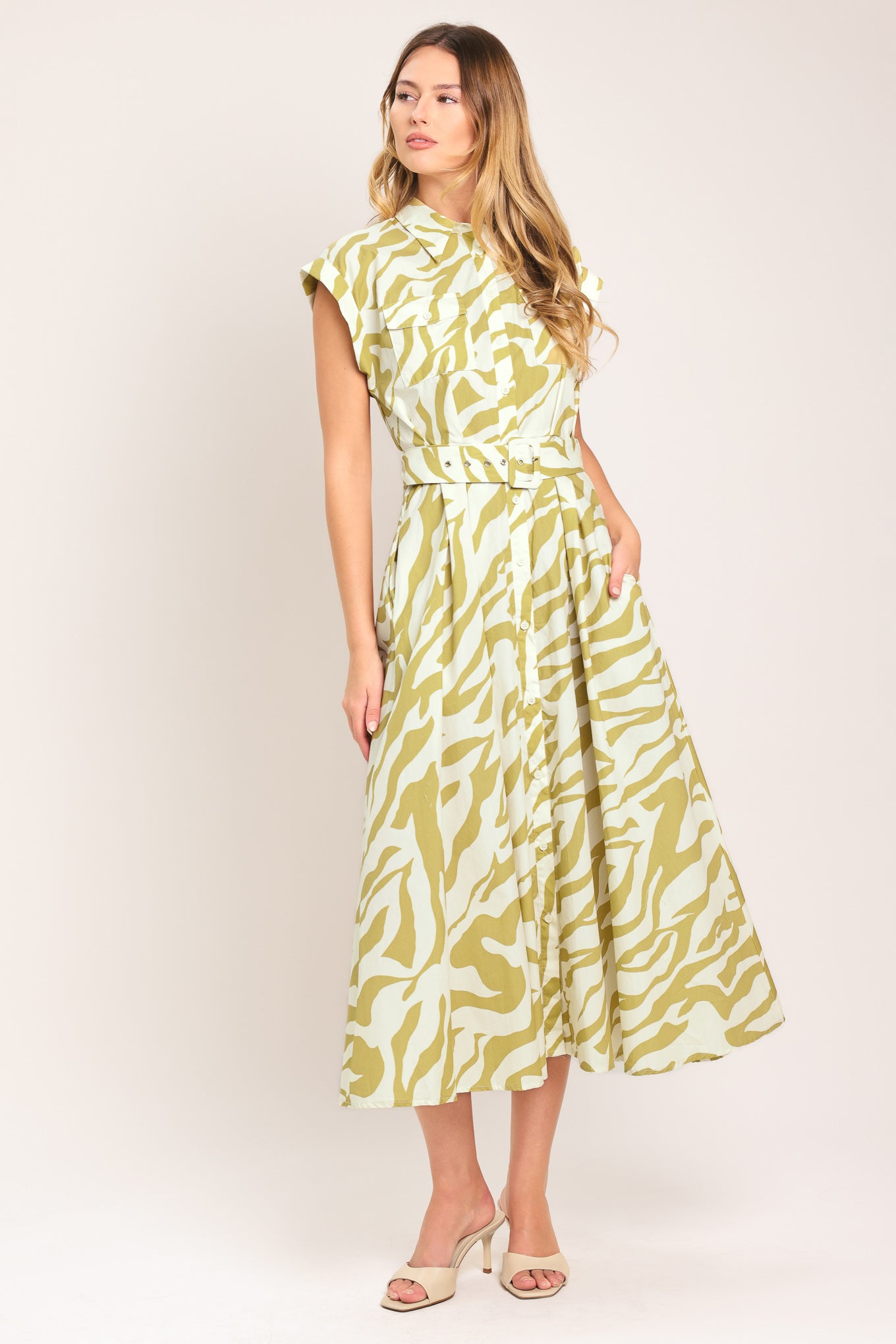 Woman wearing an ivory with taupe zebra printed midi shirt dress featuring cuffed short sleeve, front button down, self belt and side pockets | Flying Tomato