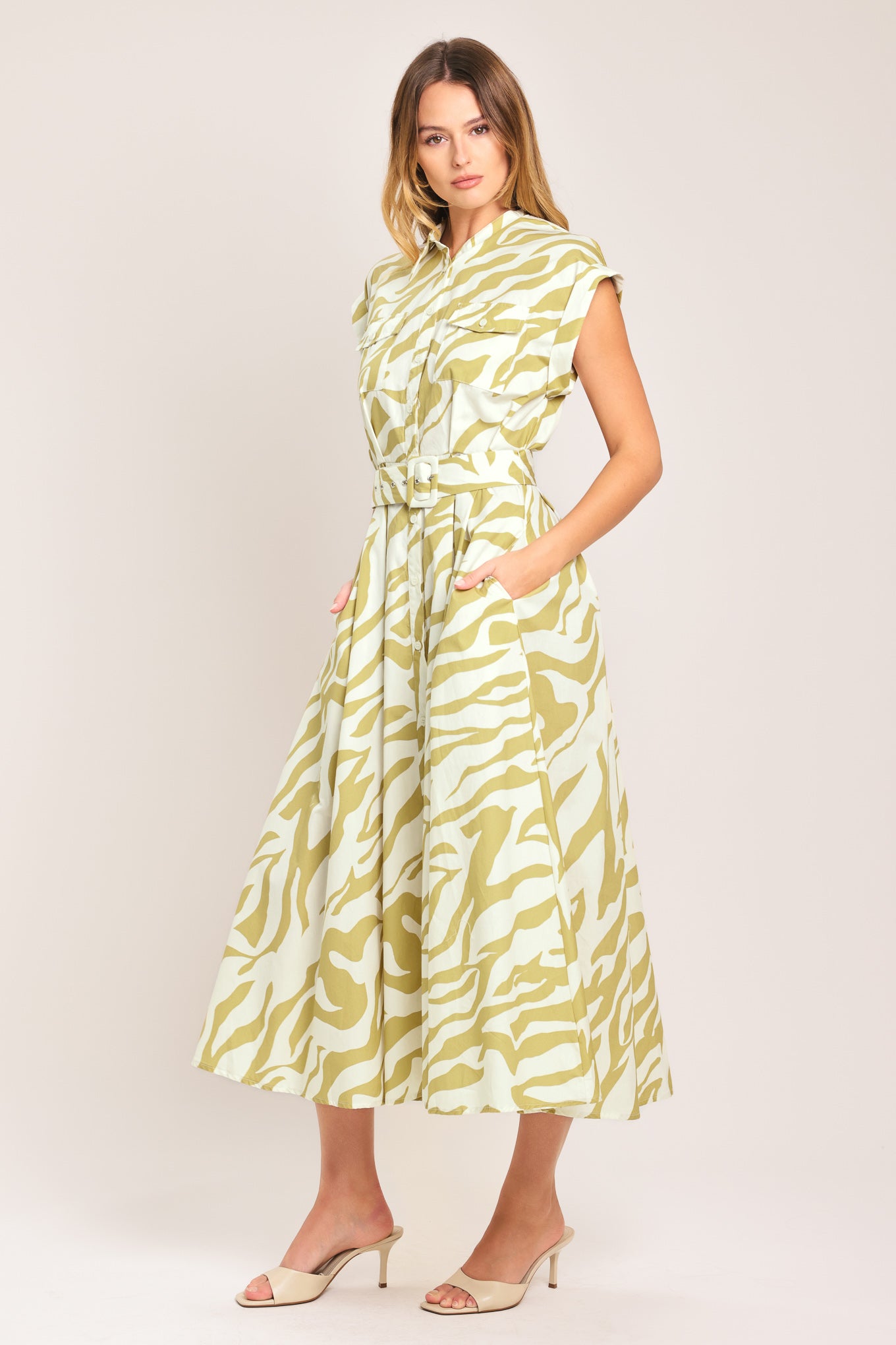 Woman wearing an ivory with taupe zebra printed midi shirt dress featuring cuffed short sleeve, front button down, self belt and side pockets | Flying Tomato