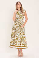 Woman wearing a camel and white short sleeve midi dress with round neckline, self sash and back neck button closure with a tropical floral pattern | Flying Tomato