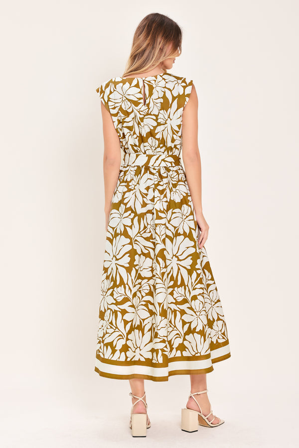 Woman wearing a camel and white short sleeve midi dress with round neckline, self sash and back neck button closure with a tropical floral pattern | Flying Tomato