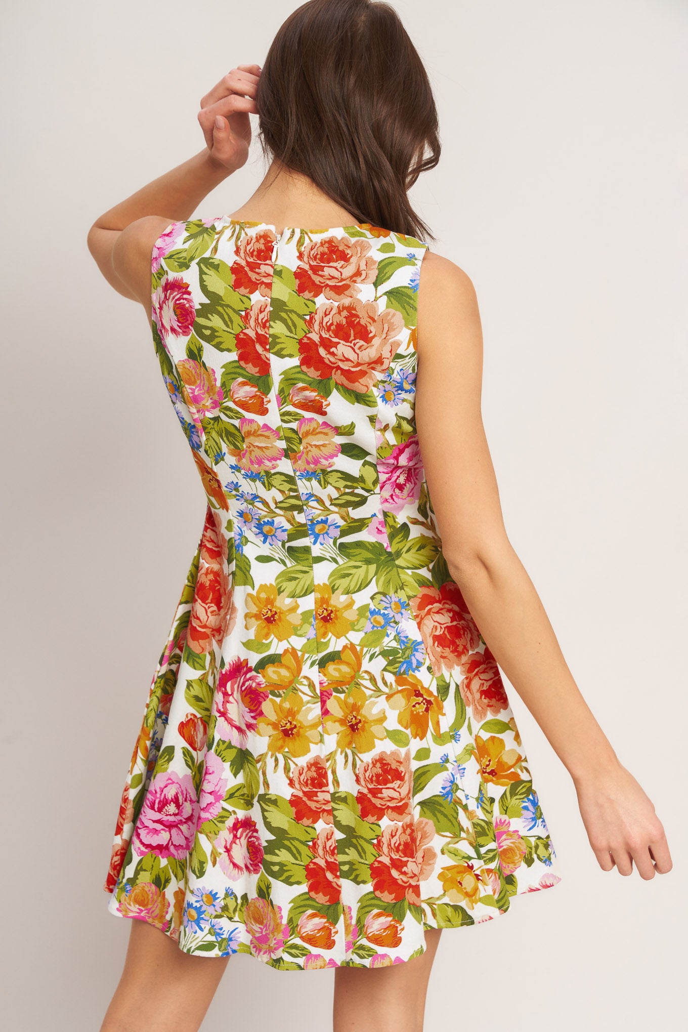 A printed woven mini dress featuring round neckline, sleeveless, circle skirt and back zipper closure