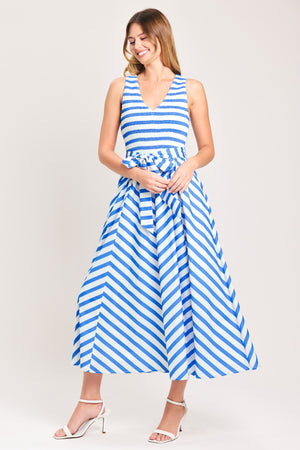 Woman wearing a blue and white striped  midi dress featuring V neckline, sleeveless, smocked bodice, self sash tie and full skirt | Flying Tomato