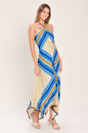 Woman wearing a blue and gold midi dress featuring halter neckline with tie, hanky hem and back zipper closure | Flying Tomato