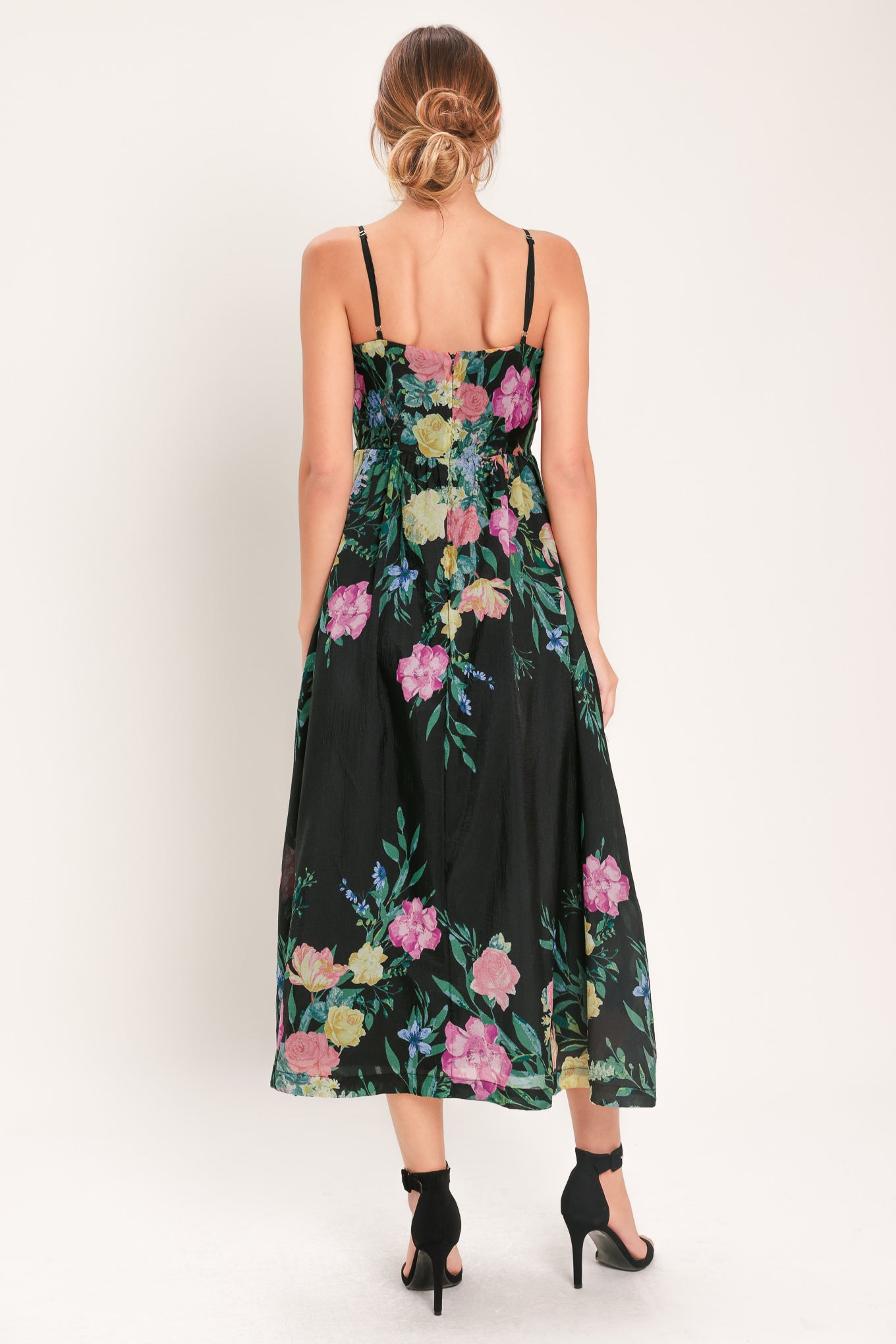 Woman wearing a black floral midi dress featuring straight neckline with shirred bust, straps, full skirt and back zipper closure | Flying Tomato