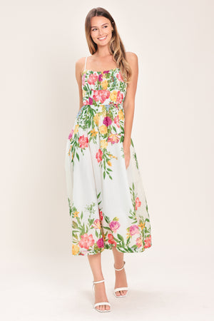 Woman wearing a white floral midi dress featuring straight neckline with shirred bust, straps, full skirt and back zipper closure | Flying Tomato