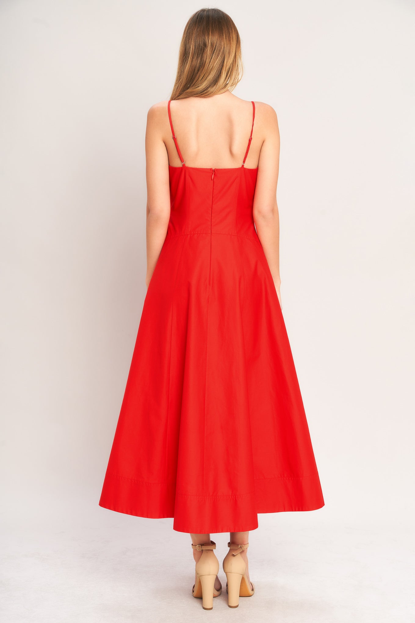 Red dress with thin straps worn by a person on a white background
