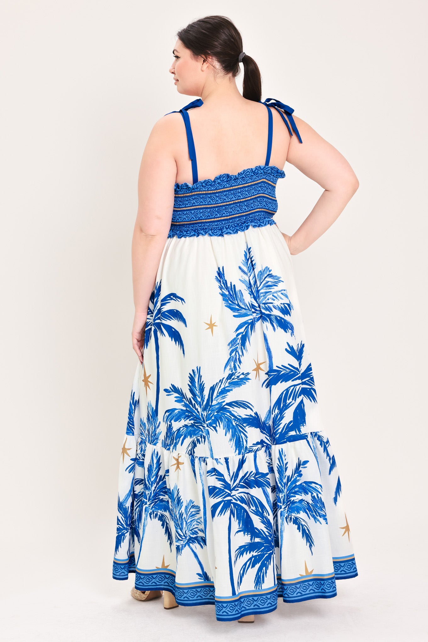 Woman wearing a blue and white dress with palm tree pattern | Flying Tomato Curve