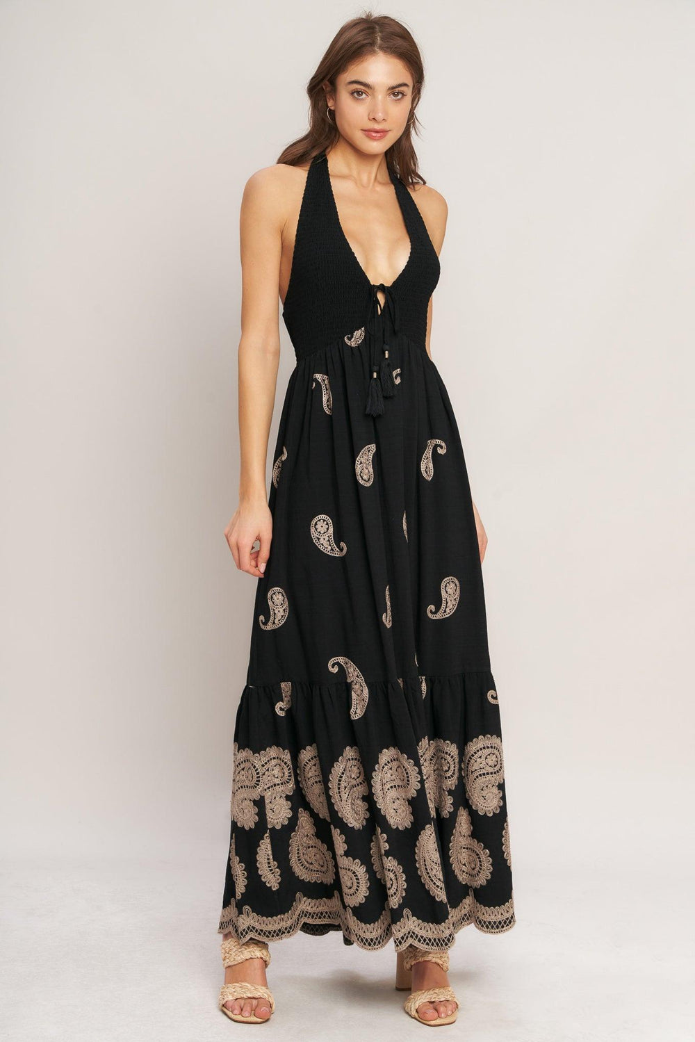 An embroidered woven midi dress featuring halter neckline, smocked bodice with front tie and bare back with back neck tie closure
